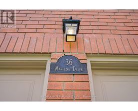 A house number 36 with a signboard and a light on the wall.