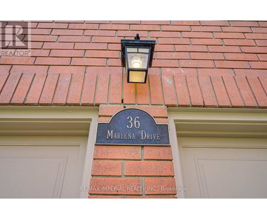 A house number 36 with a signboard and a light on the wall.