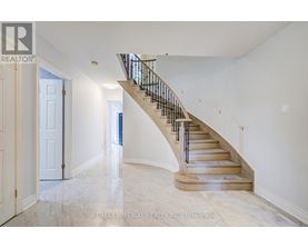 A spacious hallway with a staircase leading to the second floor.