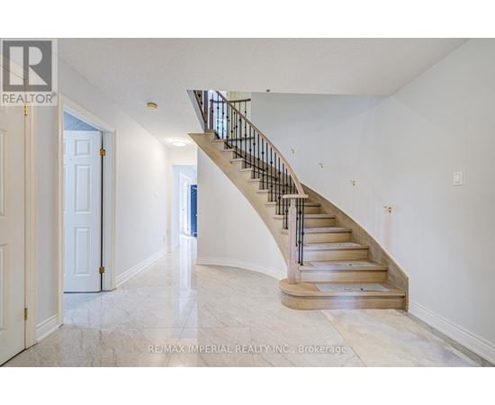 A spacious hallway with a staircase leading to the second floor.