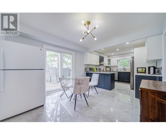 A kitchen with a white fridge and a table with chairs.
