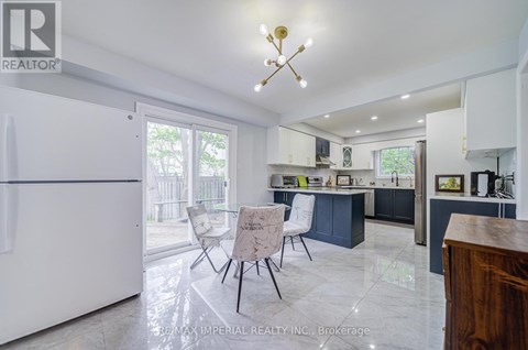 A kitchen with a white fridge and a table with chairs.