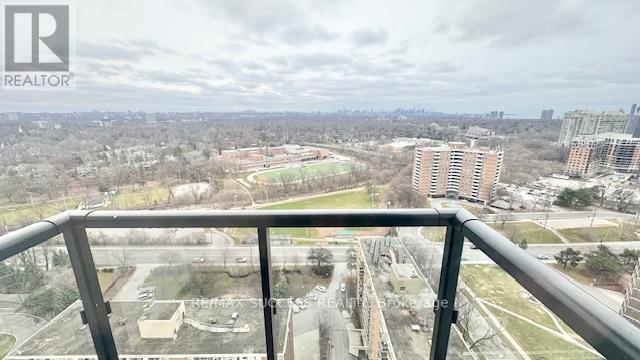A balcony overlooks a cityscape with buildings and greenery.
