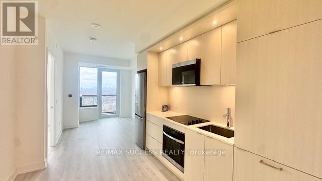 A modern kitchen with white cabinets and a microwave above the stove.