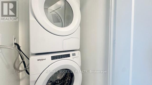 A Whirlpool washing machine is stacked on top of a RE/MAX Success Realty Brokerage sign.