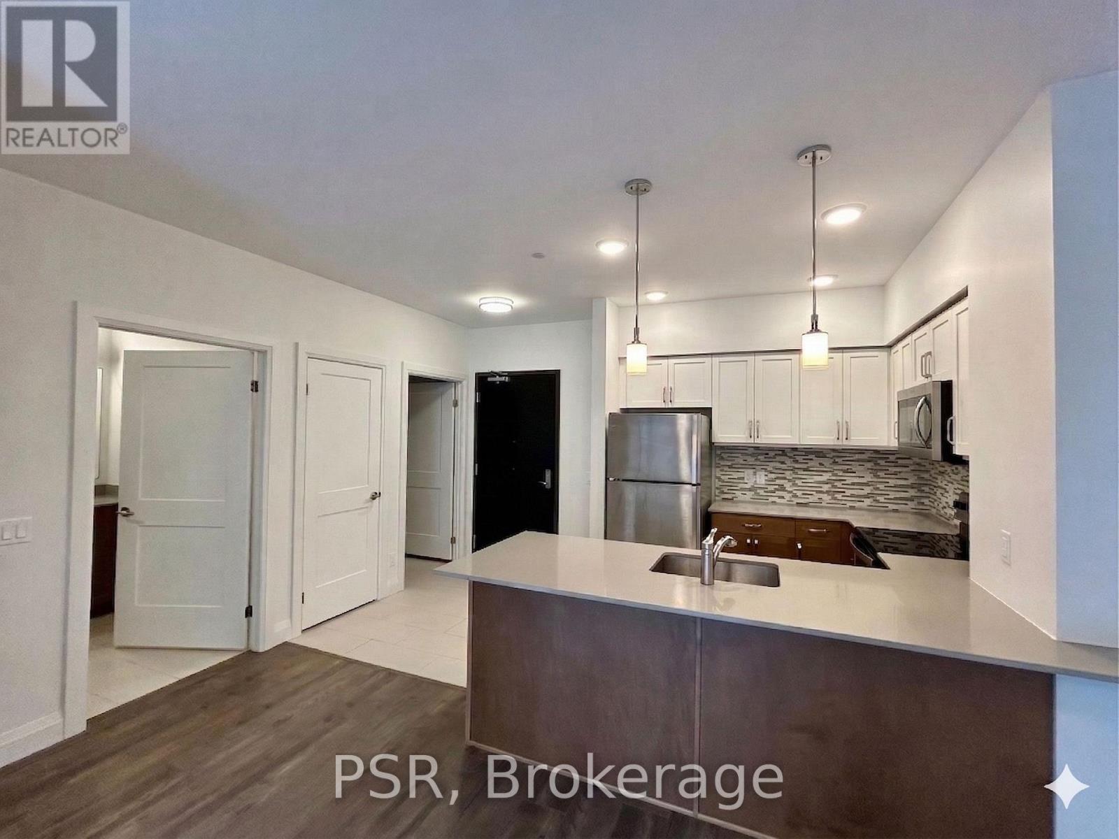 A kitchen with a sink and a refrigerator in a house.