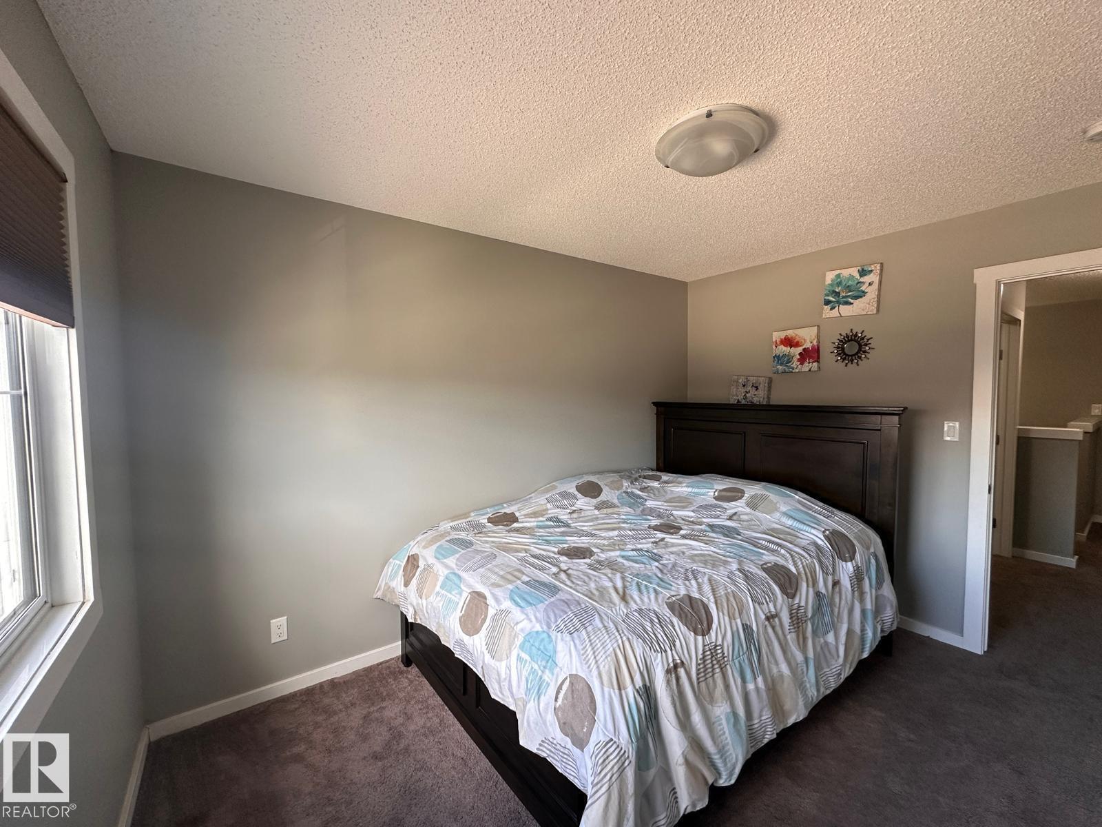 A bedroom with a bed and a window.