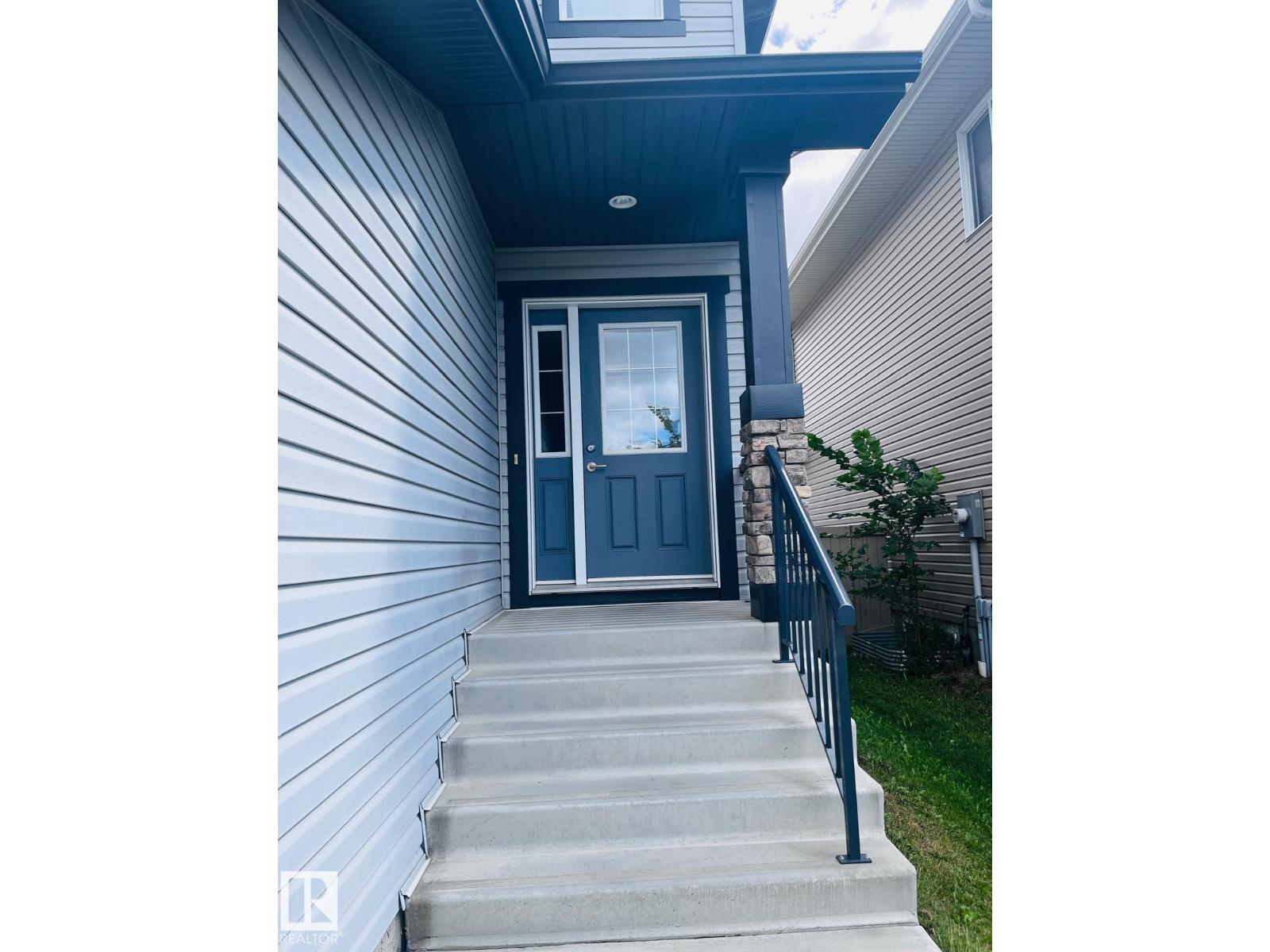 A blue door is on the side of a house.
