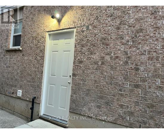 A white door is on the left side of a brick wall.