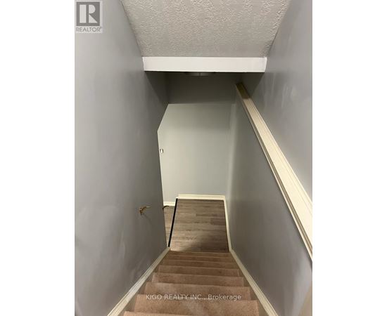 A stairway with a carpeted runner and wooden steps.