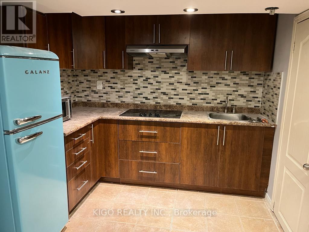 A kitchen with a blue fridge and wooden cabinets.