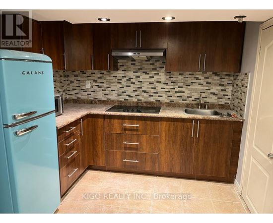 A kitchen with a blue fridge and wooden cabinets.