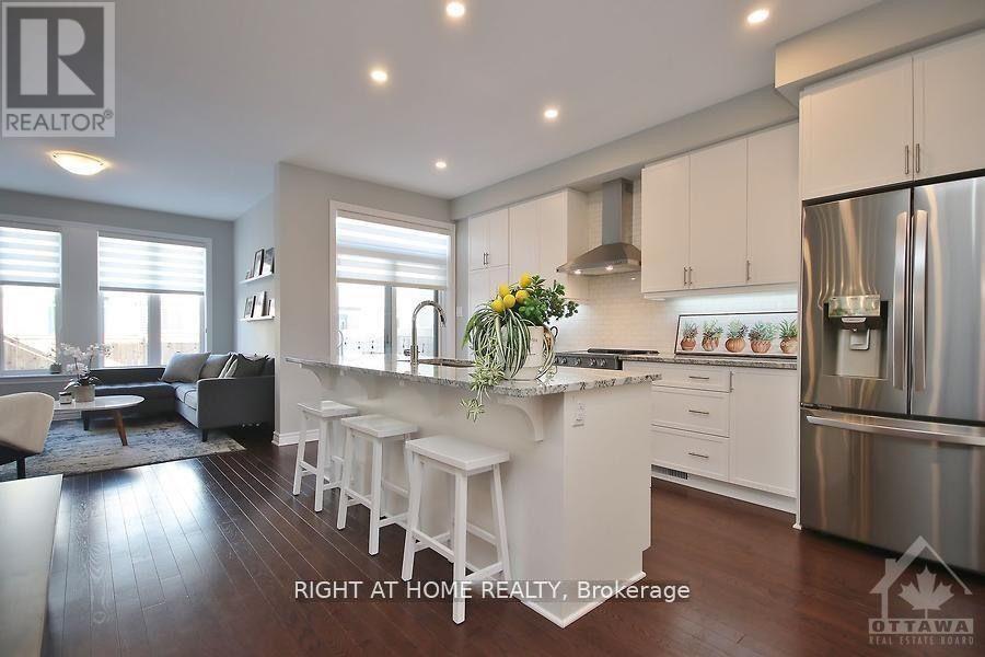 A modern kitchen with white cabinets and stainless steel appliances.