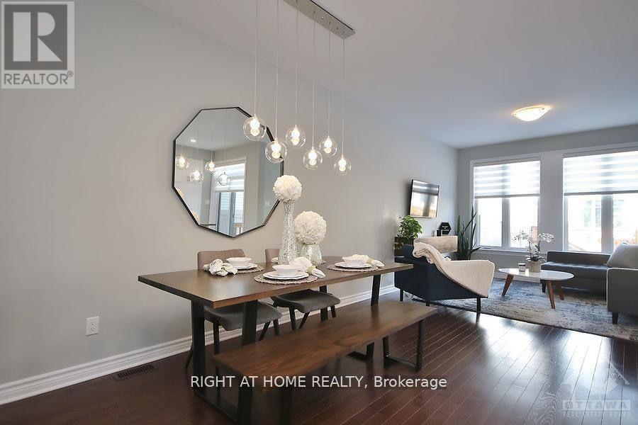A dining room with a table set for two and a mirror on the wall.