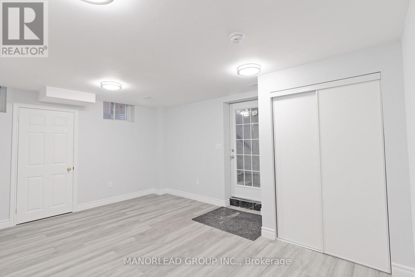 A white room with a door and a window.