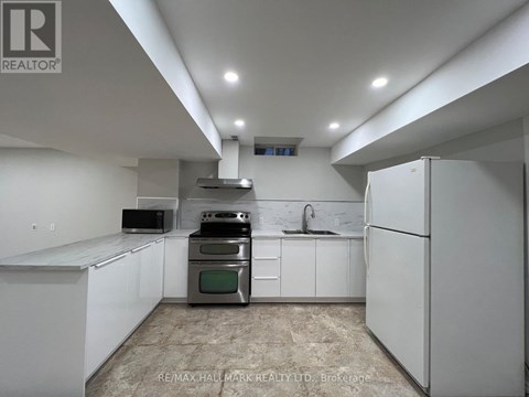 A kitchen with white cabinets and a refrigerator.