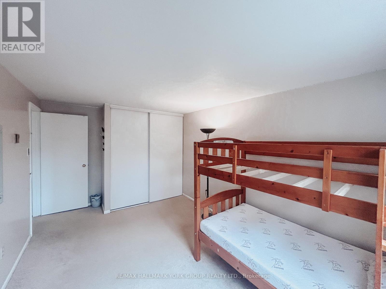A bedroom with a bunk bed and a white wall.