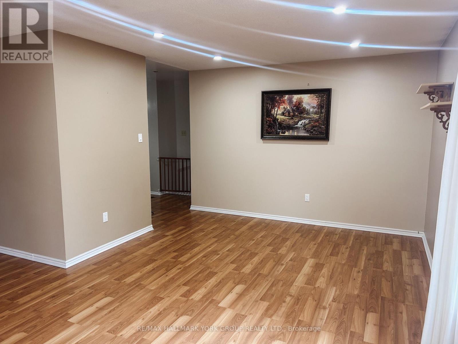 A room with wooden flooring and a painting on the wall.