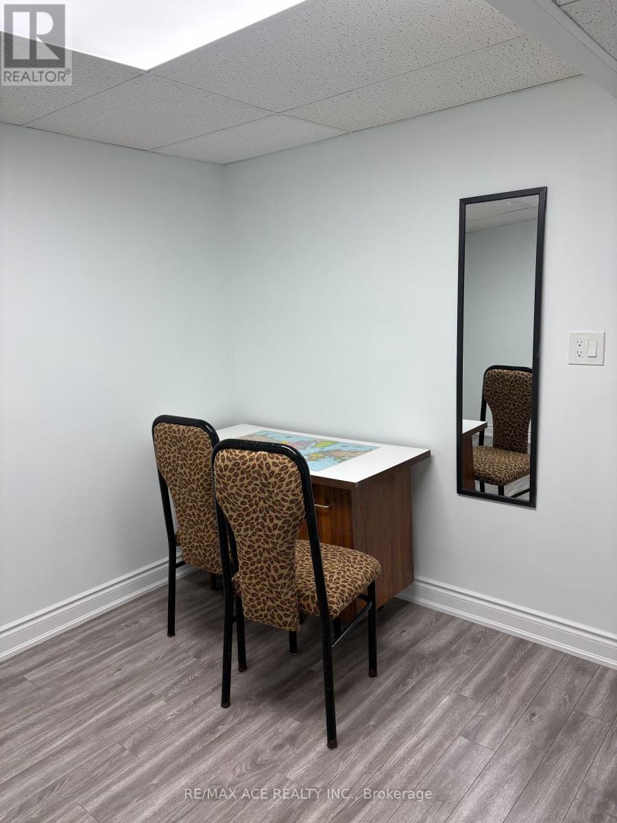 A room with a desk, two chairs and a mirror.