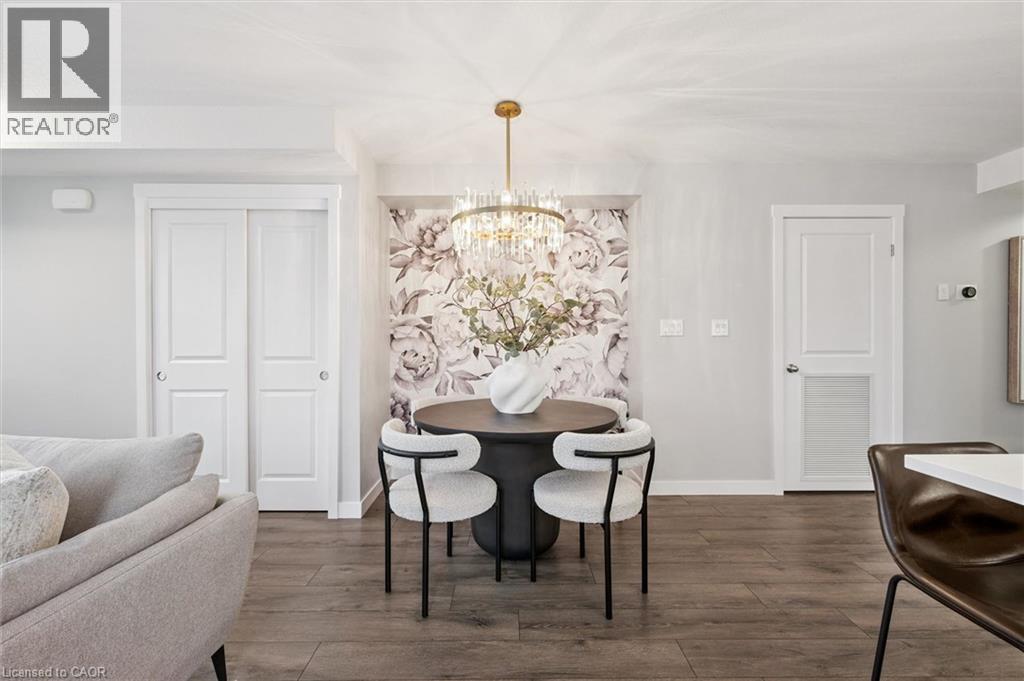 A dining room with a table set for two and a chandelier hanging from the ceiling.