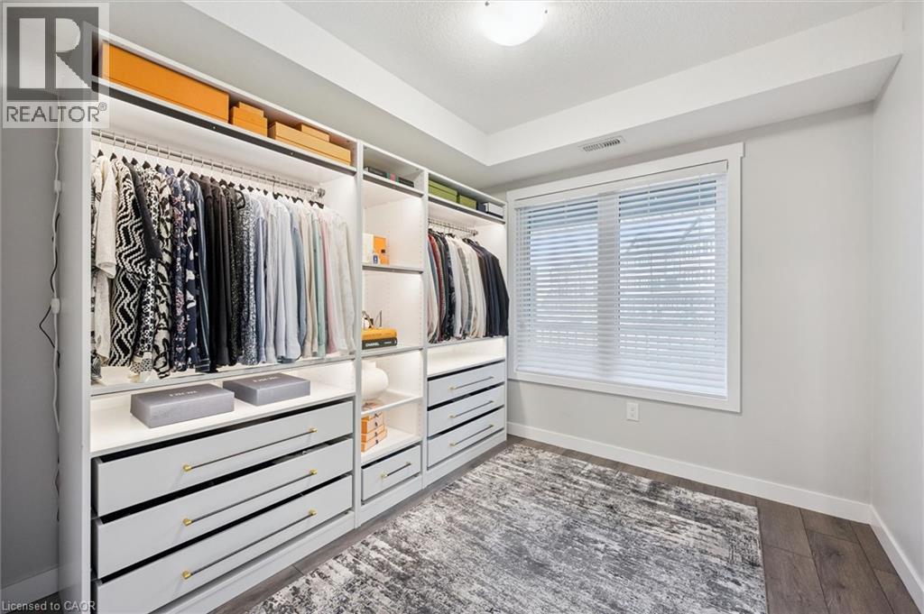 A spacious walk-in closet with white shelving and drawers, organized with various clothing items.