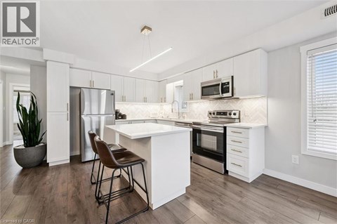 A modern kitchen with white cabinets and a center island.