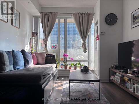 A living room with a grey couch, a coffee table, and a flat screen TV.