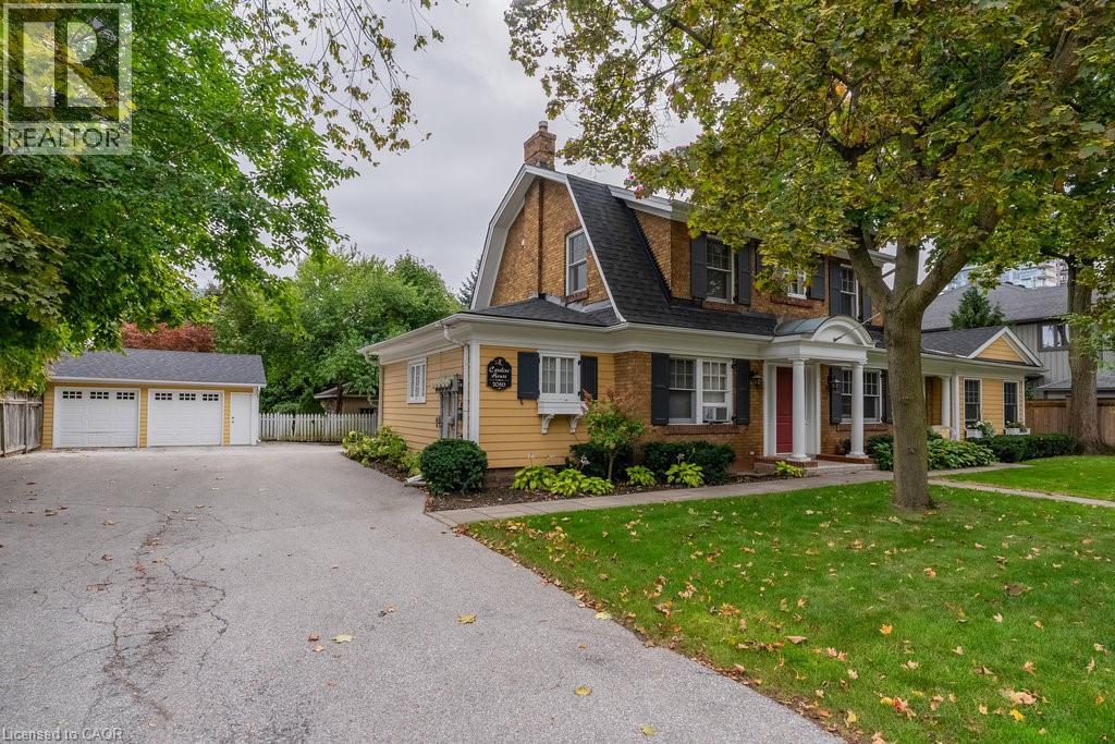 A house with a driveway and a tree in front.