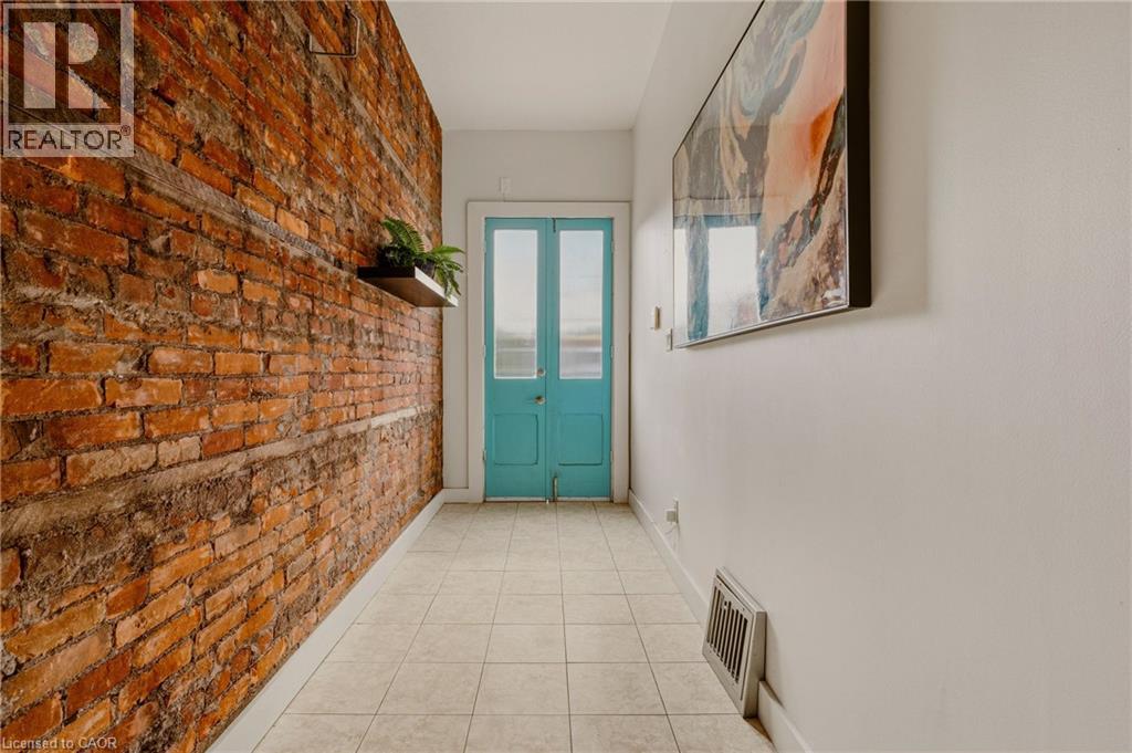 A room with a blue door and a plant on the brick wall.