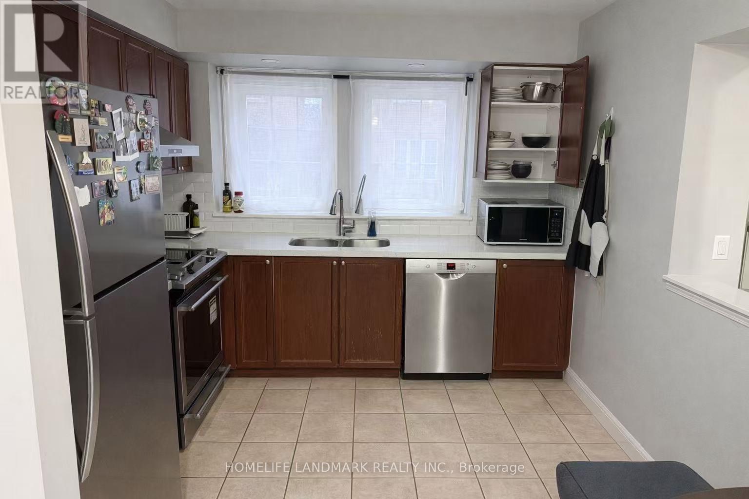 A kitchen with a refrigerator, stove, and sink.