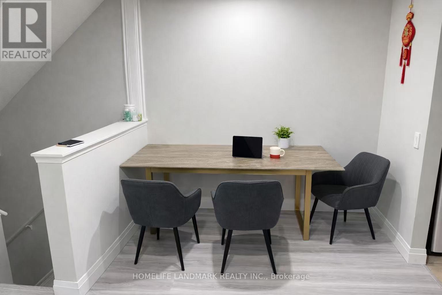 A dining room with a table and chairs.