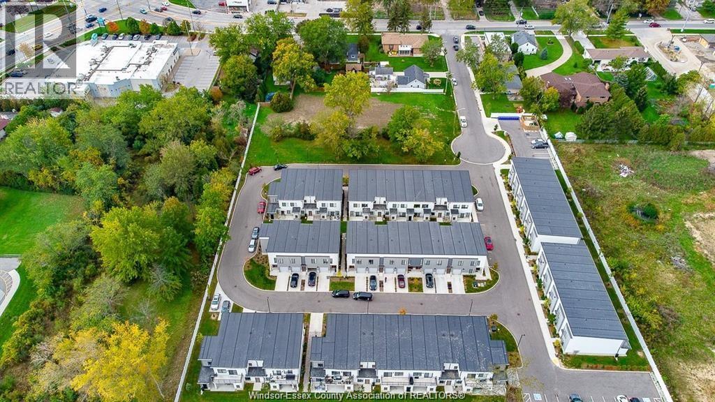 An aerial view of a large building surrounded by trees and a parking lot.