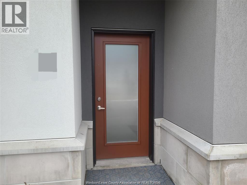 A brown door with a glass panel is set in a white wall.