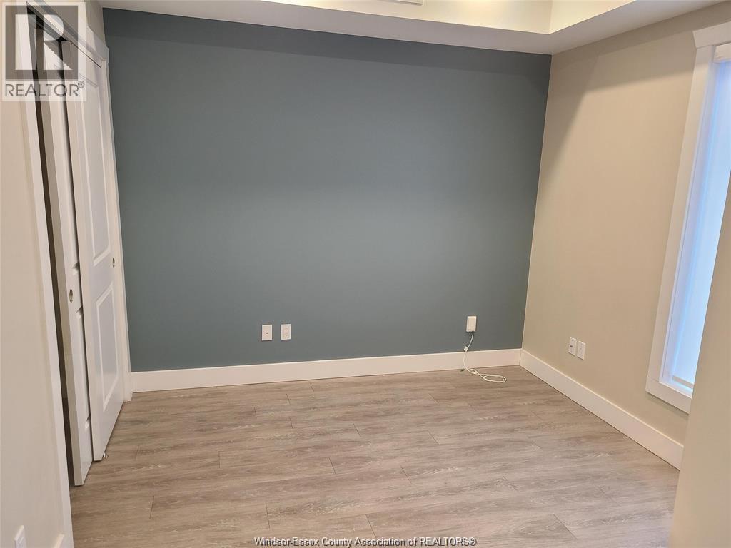 A room with a grey wall and wooden flooring.