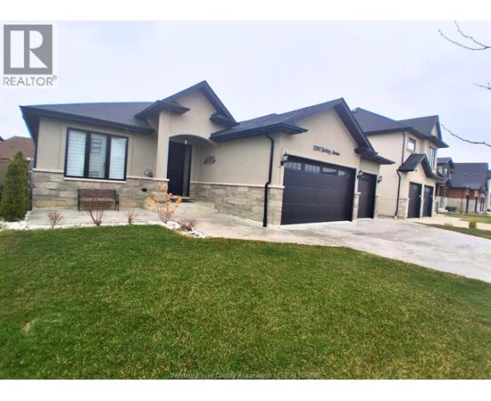 A house with a large front yard and a garage door.