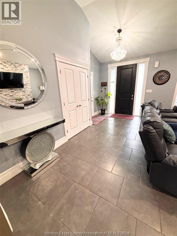 A living room with a grey couch and a mirror on the wall.
