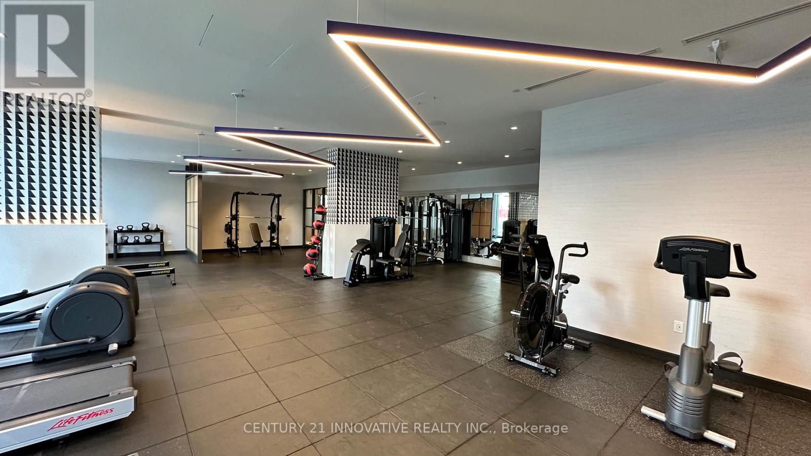 A gym with a variety of equipment including treadmills, stationary bikes, and weight machines.