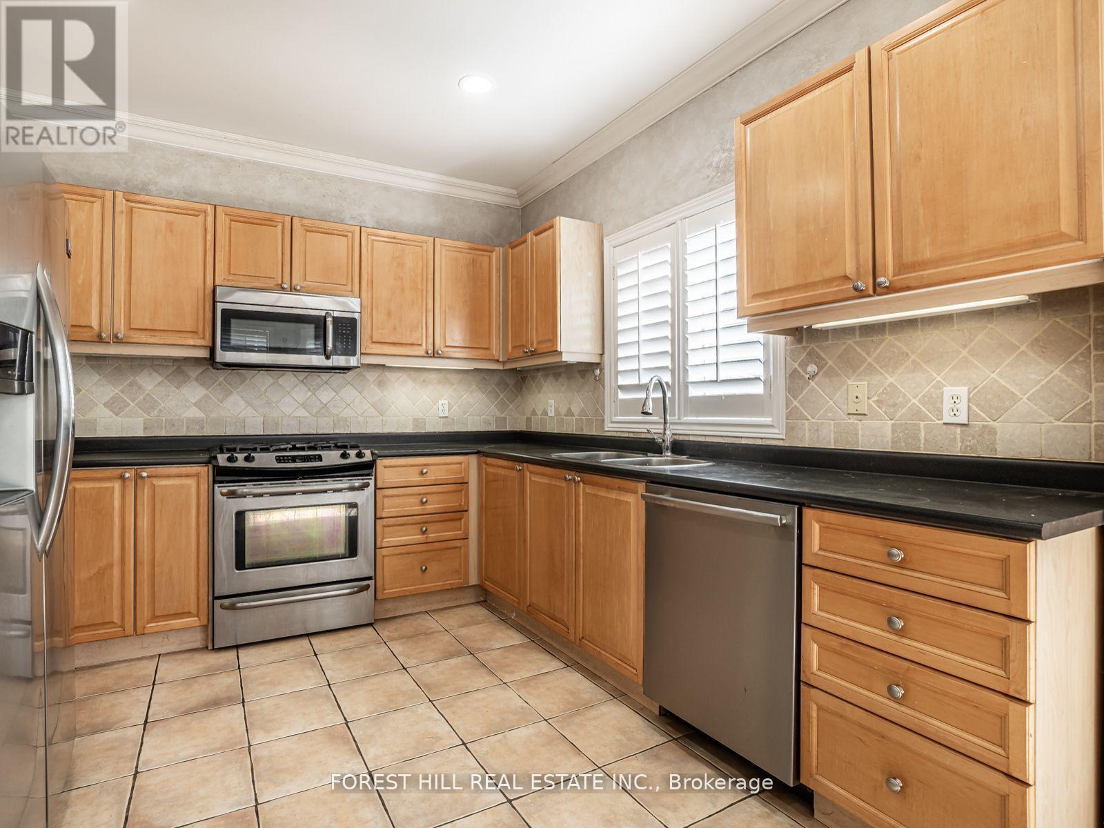 A kitchen with wooden cabinets and a black countertop.