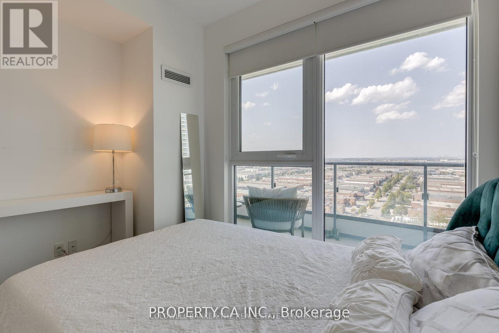 A bedroom with a large bed and a view of the city.