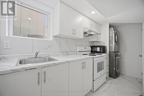 A kitchen with white cabinets and a marble countertop.