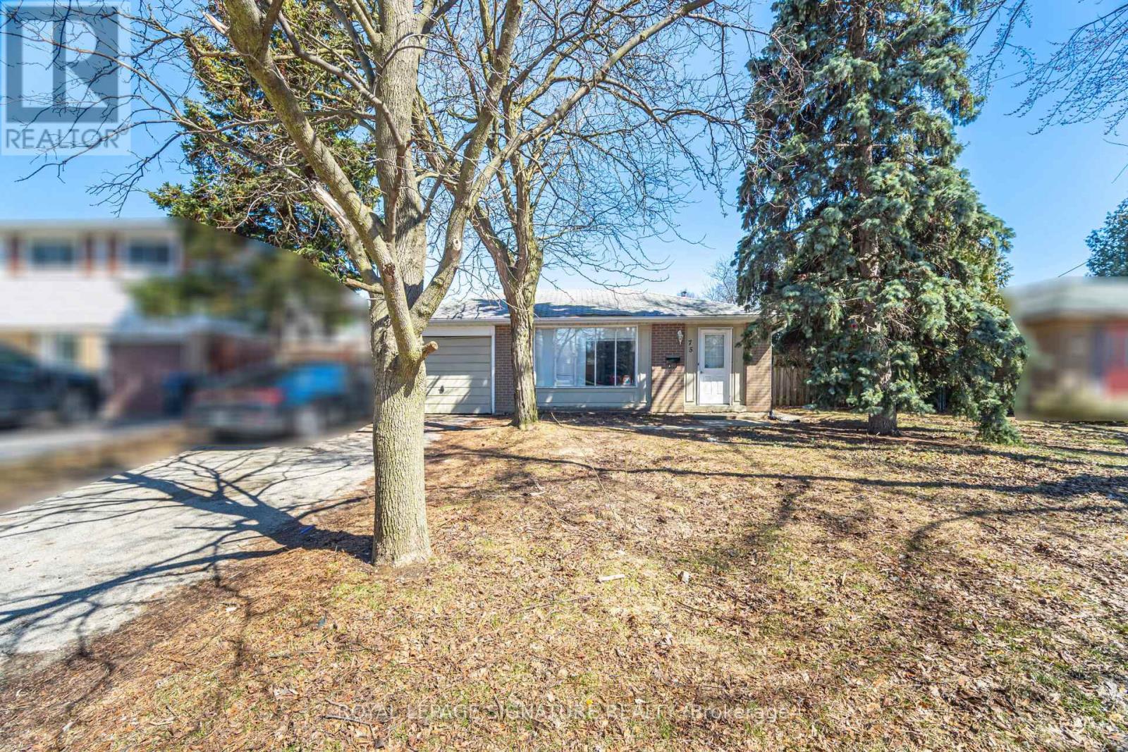 A real estate photo of a house with a tree in front.