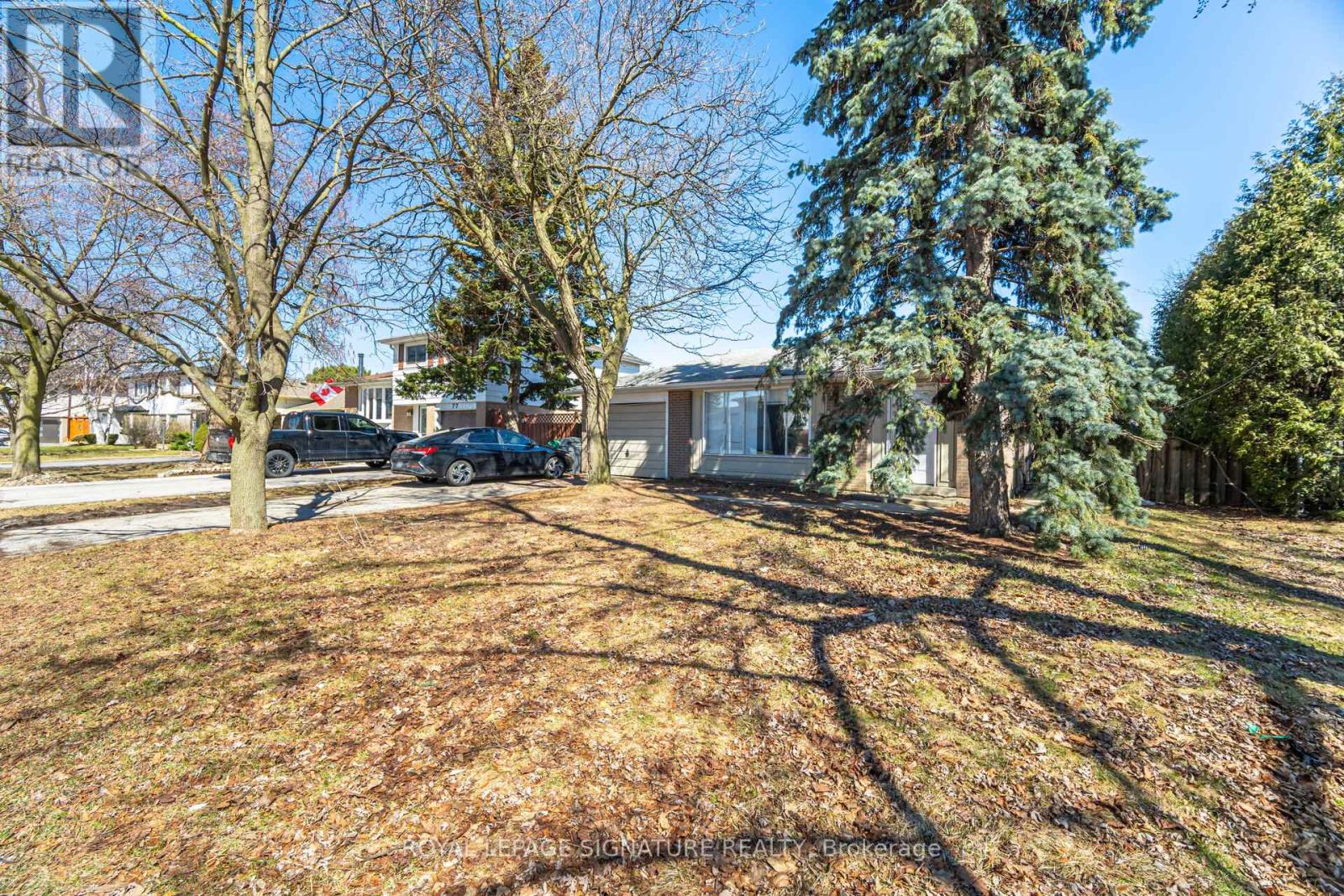 A house with a driveway and trees in the background.