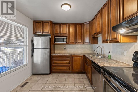 A kitchen with wooden cabinets and a stainless steel refrigerator.