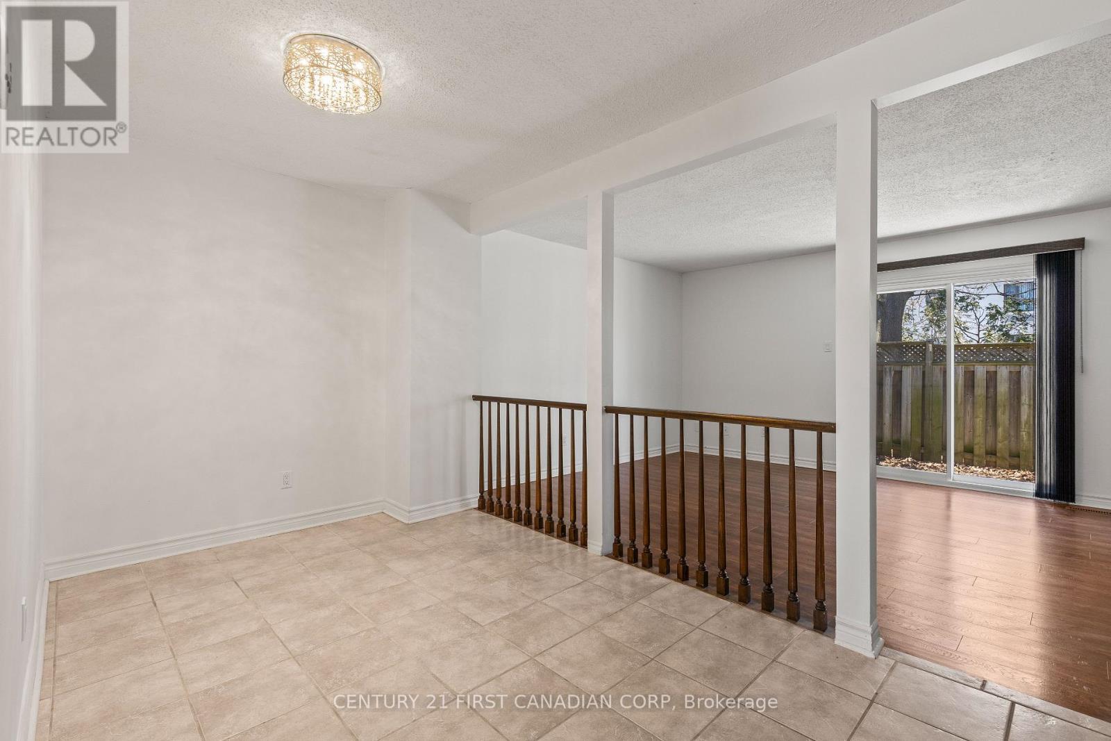 A spacious room with a balcony and a light fixture on the ceiling.