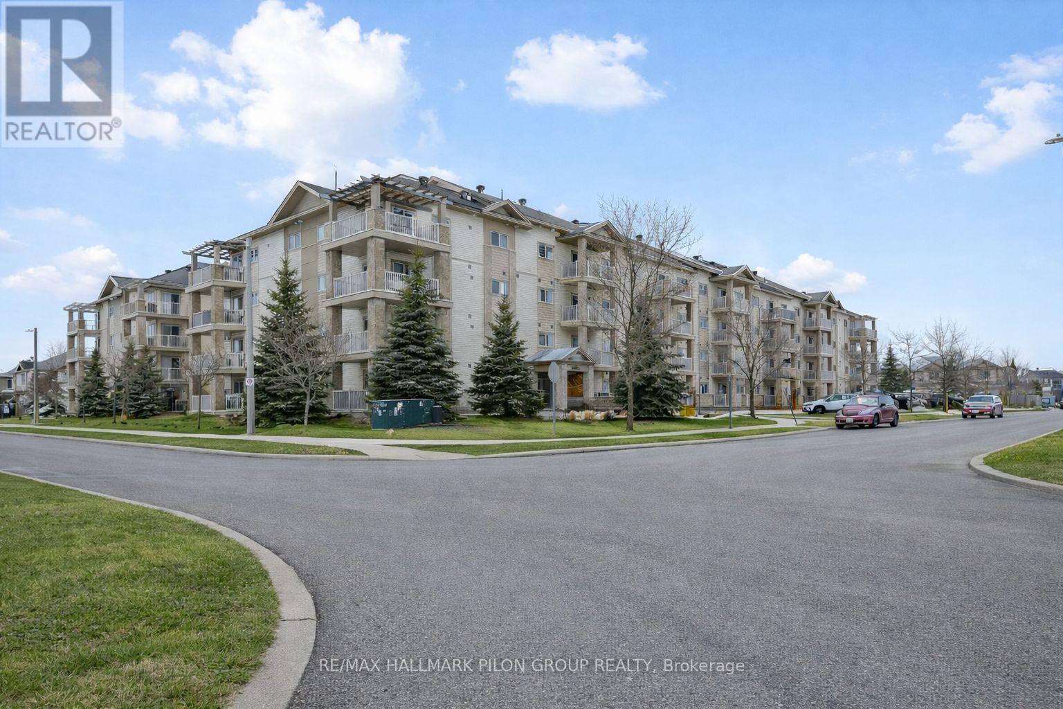 A large apartment complex with a parking lot in front.