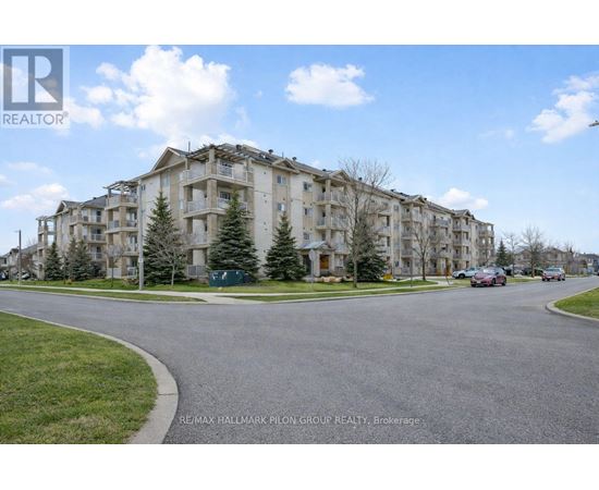 A large apartment complex with a parking lot in front.