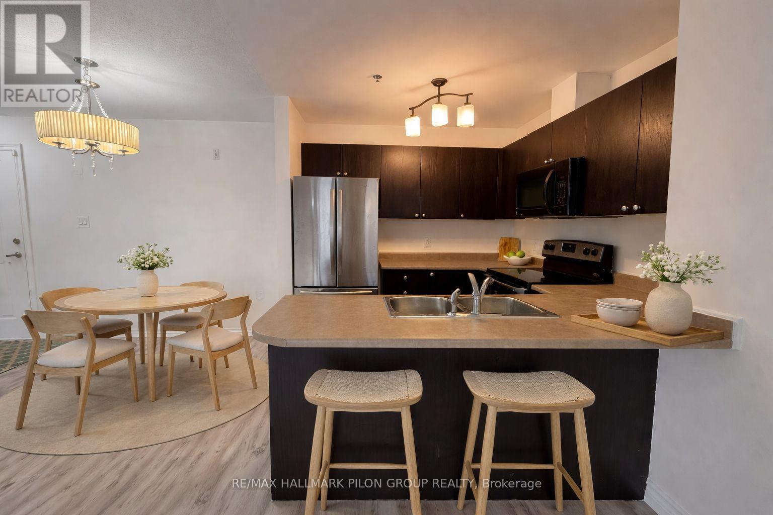 A modern kitchen with a bar stool and a dining table.