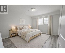 A bedroom with a bed, nightstand, and window.