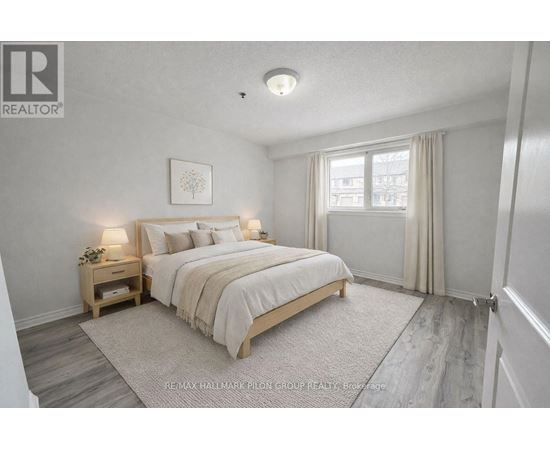 A bedroom with a bed, nightstand, and window.