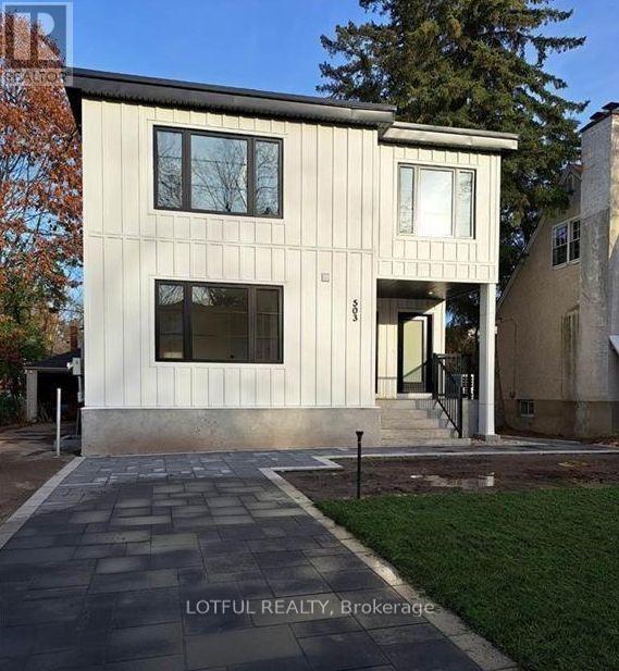 A modern house with a stone walkway in front.